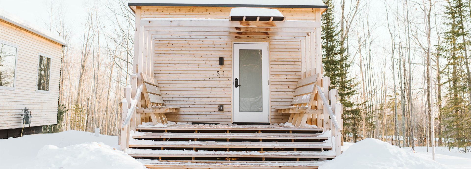 a wooden house with snow on the front door