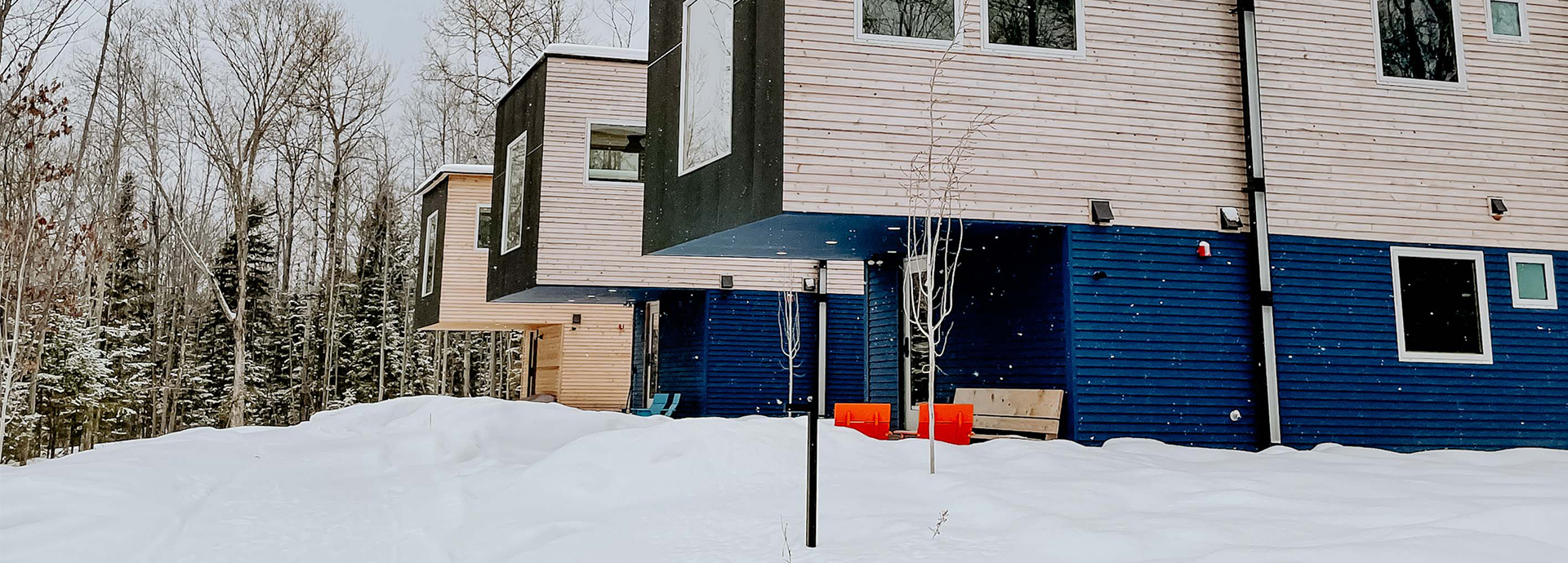 a house with a blue door and a red chair in the snow