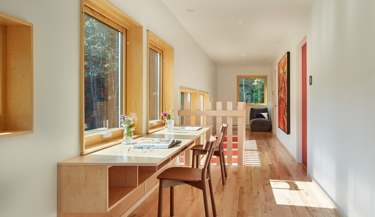 a long desk with chairs and a painting on the wall