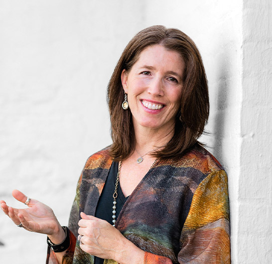 a woman smiling and holding her hands out