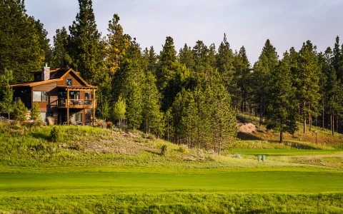 a house on a hill with trees in the back