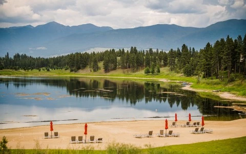 a lake with chairs and trees around it