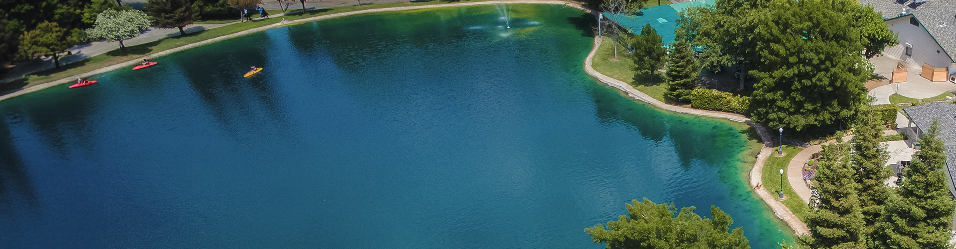 a body of water with trees and buildings around it
