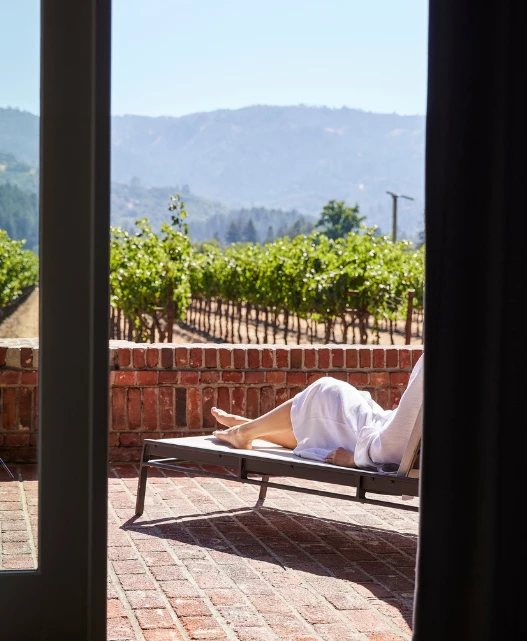 a woman lying on a lounge chair outside