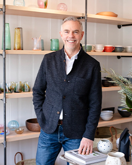 a man standing in front of shelves of bowls