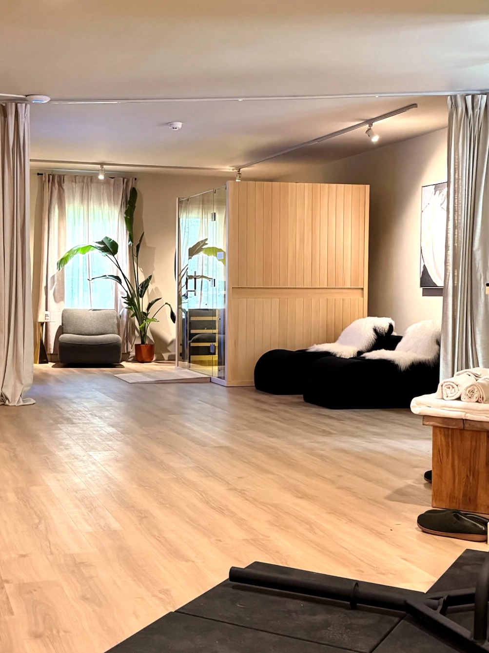 a room with a wood floor and white curtains