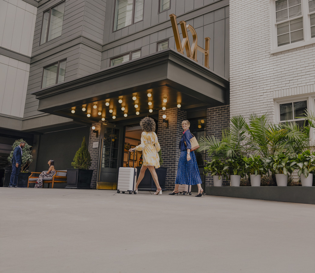a group of women walking outside of a hotel