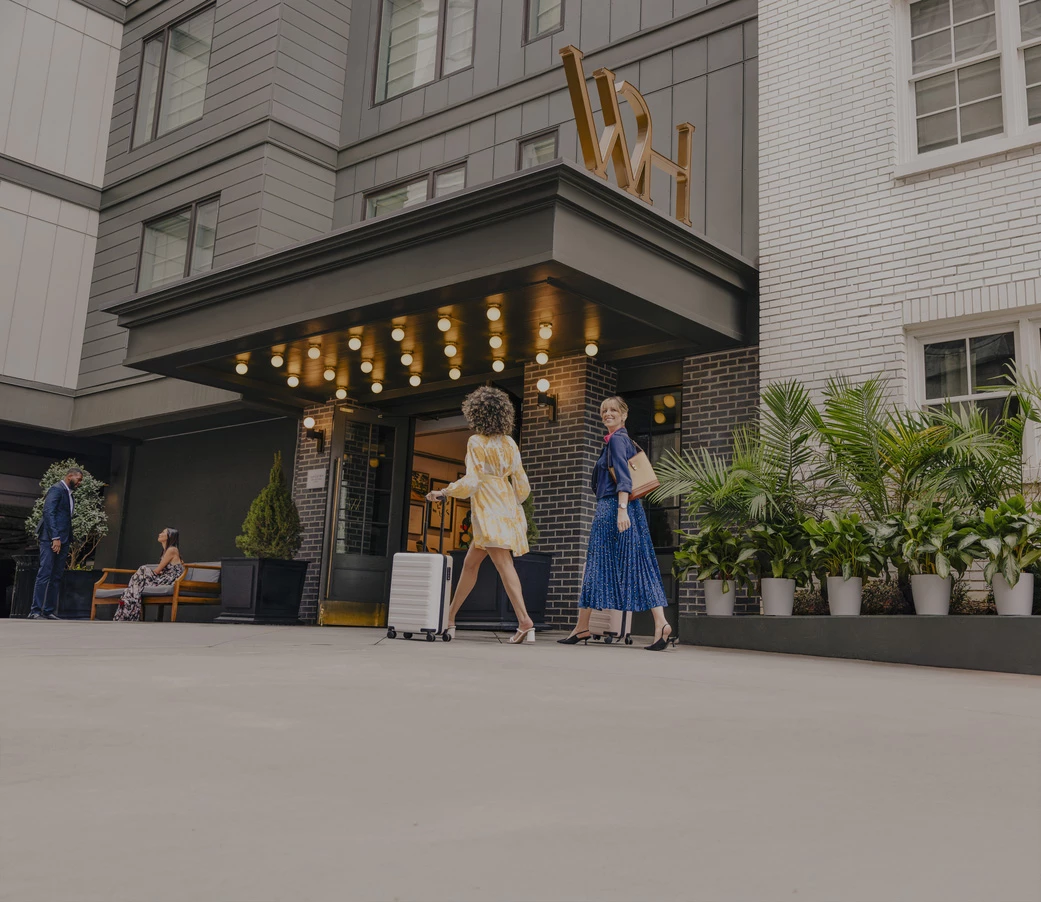 a group of women walking outside of a hotel
