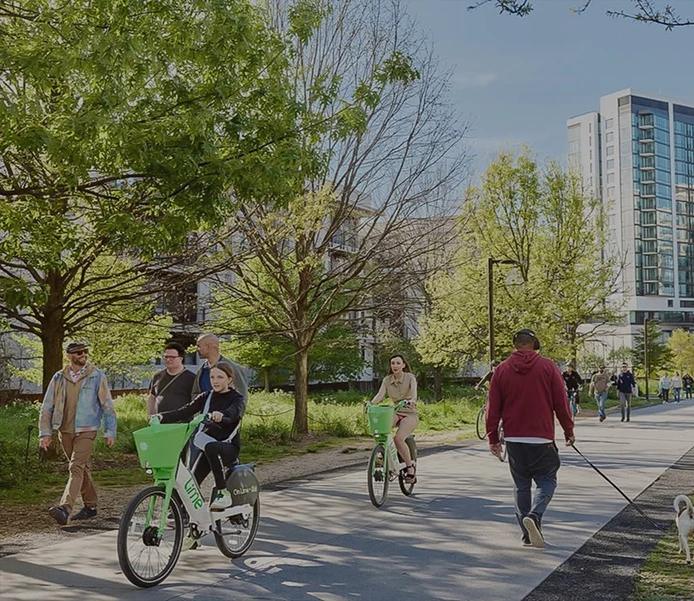 a group of people riding bicycles on a sidewalk