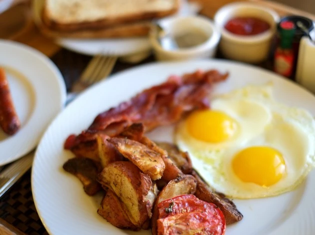 breakfast plate with eggs, bacon, and potatoes