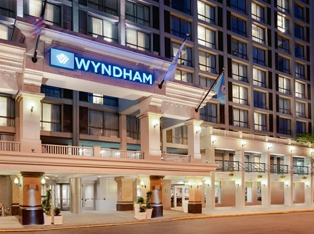 the hotel building with a blue lit up sign of the hotel name
