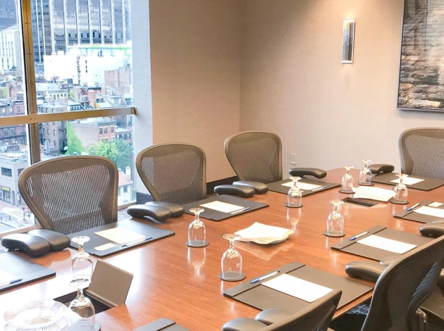 a conference room with chairs and a table with wine glasses