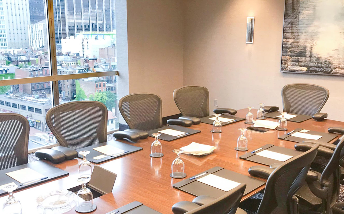 a conference room with a table with chairs and wine glasses