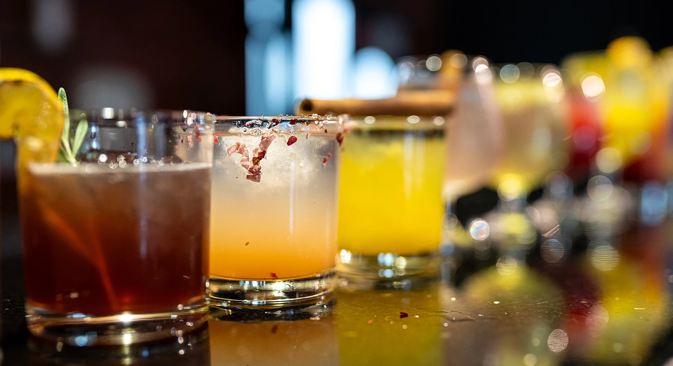 a group of glasses with different colored liquid