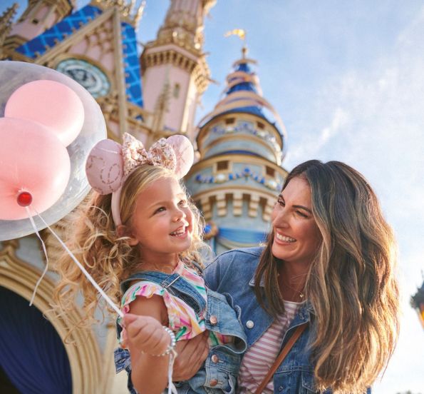 a woman holding a child with balloons