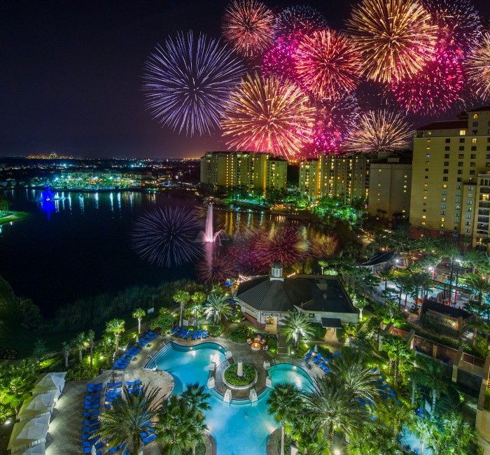 fireworks above a pool and buildings
