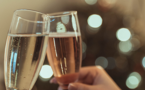 a pair of hands holding up champagne glasses