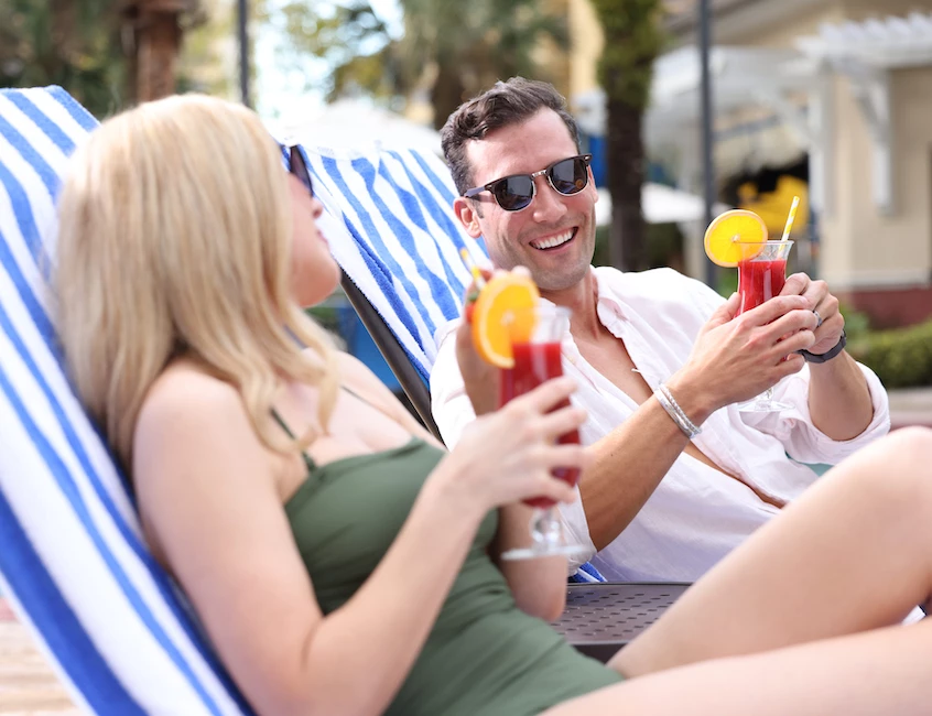 a man and woman sitting on a chair holding drinks