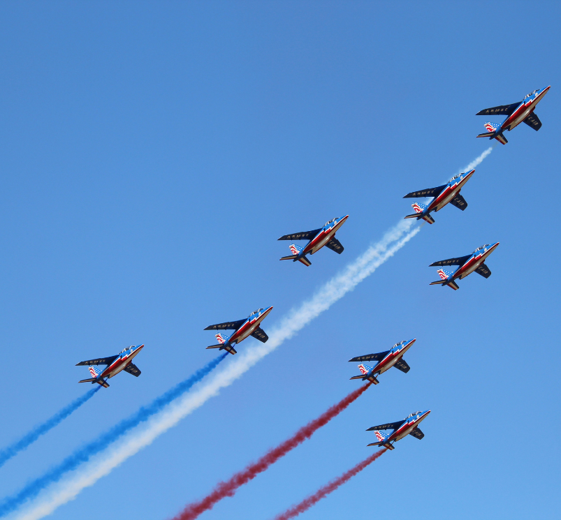 a group of airplanes flying in formation with smoke trails