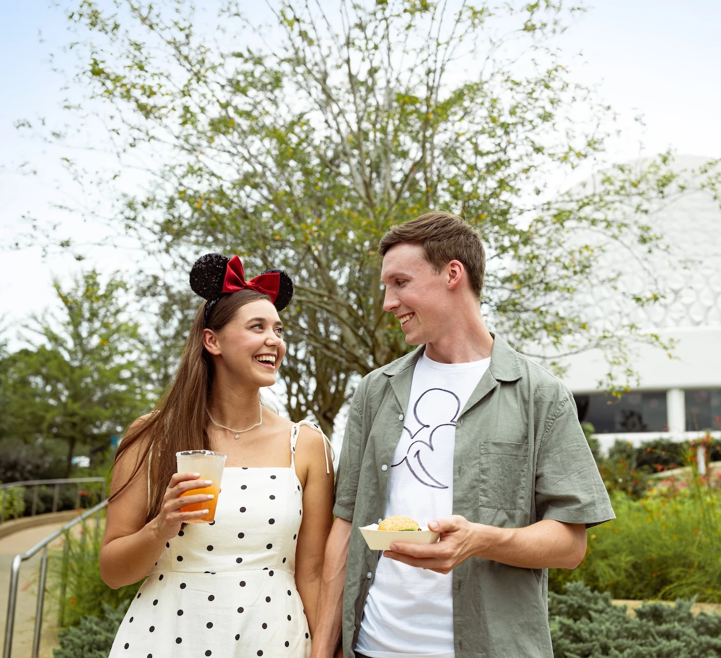 a man and woman holding food and drinks