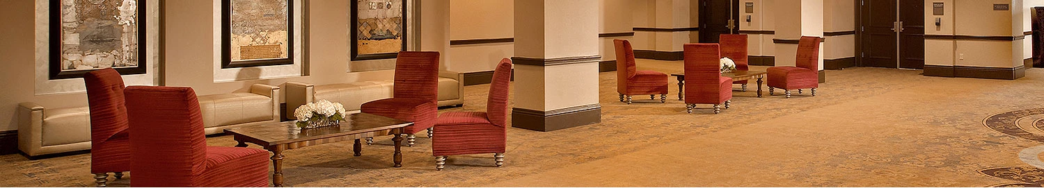lobby seating area with columns and high back red chairs around tables