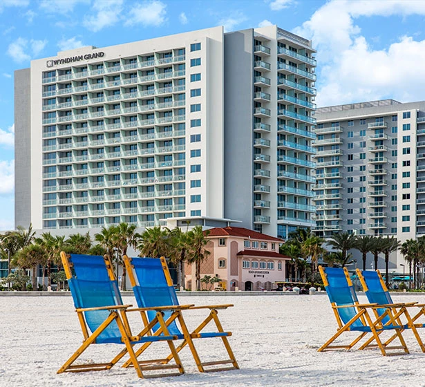 blue chairs on sand overlooking a white beach