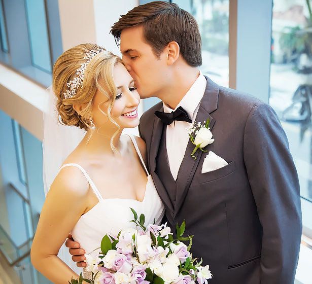 groom kissing bride on the cheek on wedding day