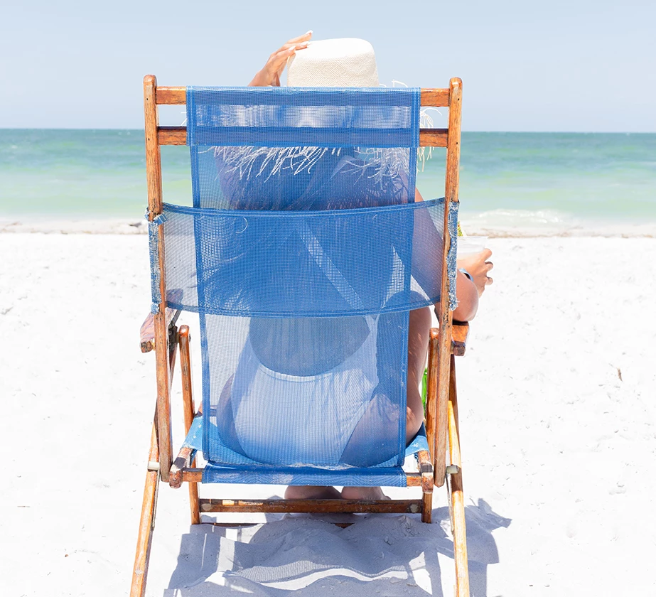 a person sitting in a chair on a beach