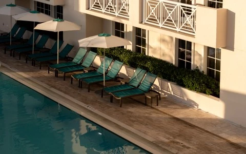 a pool with umbrellas and lounge chairs