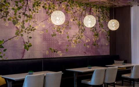 a room with tables and chairs and a wall with a floral mural