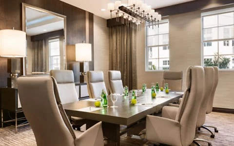 meeting room with tall beige leather chairs around a long rectangular chair