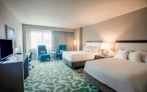 hotel room with double beds and two accent chairs