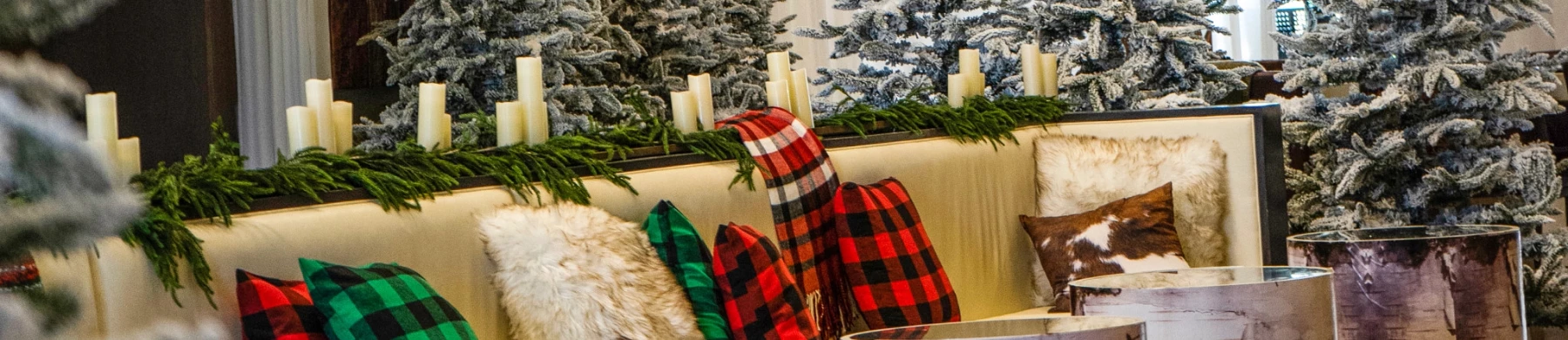 a group of christmas trees with plaid blankets and candles