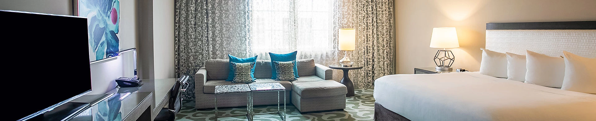 suite room with gray couch by the window