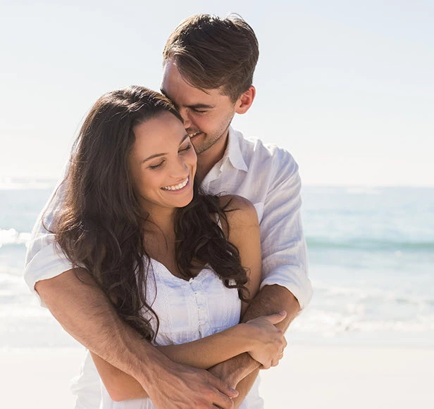 couple taking engagement pictures by the beach