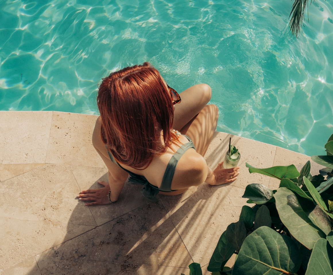 a woman sitting by a pool in Fall