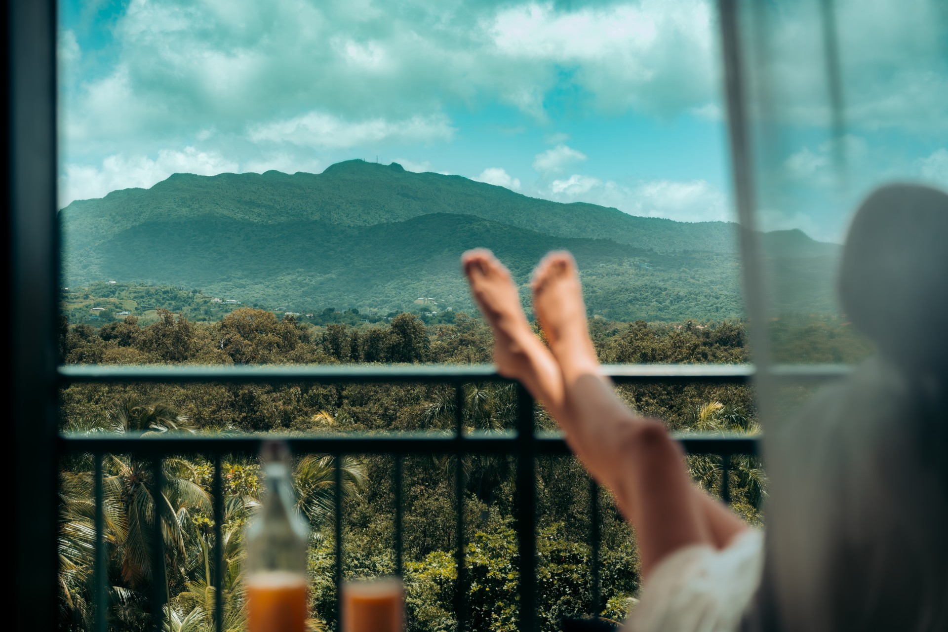 a person's legs on a balcony overlooking a mountain