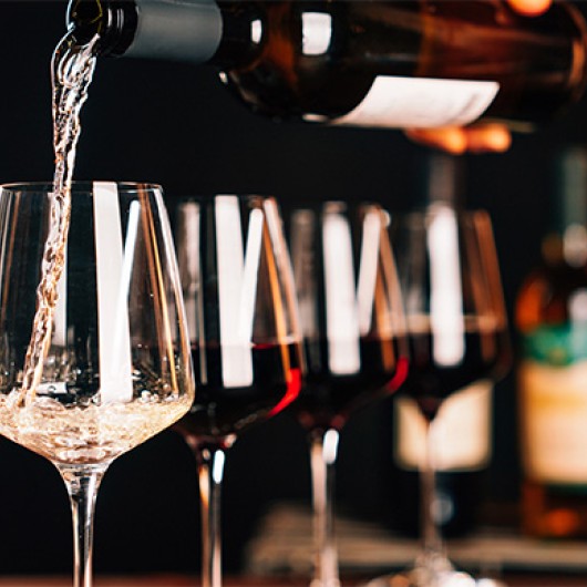 a person pouring wine into a glass