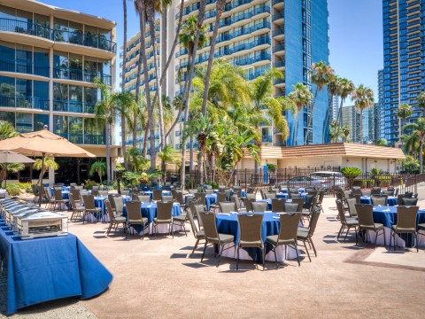a group of tables and chairs outside with palm trees