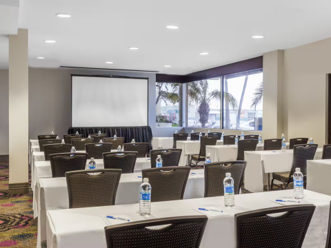 a room with tables and chairs and a projector screen