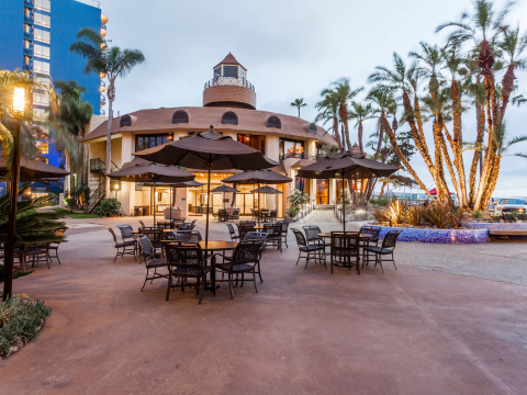 a building with tables and umbrellas