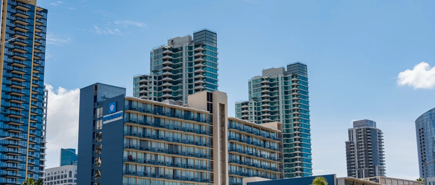 a group of buildings with trees and blue sky
