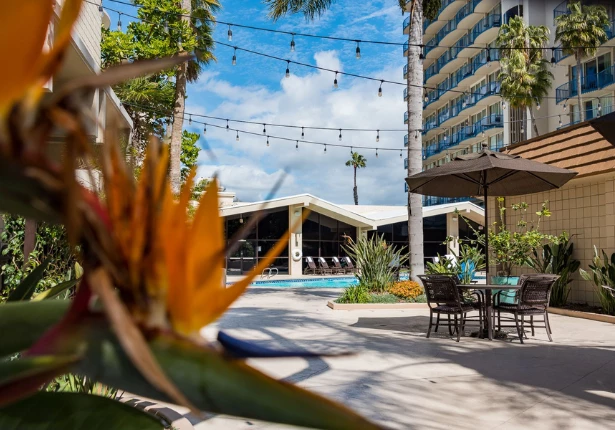 a patio with umbrellas and chairs and a pool