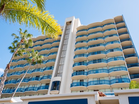 a building with balconies and palm trees
