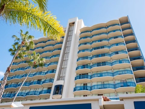 a building with balconies and palm trees