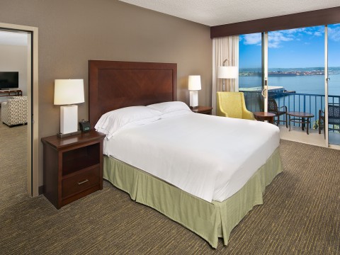 a hotel room with a large bed and a view of the water