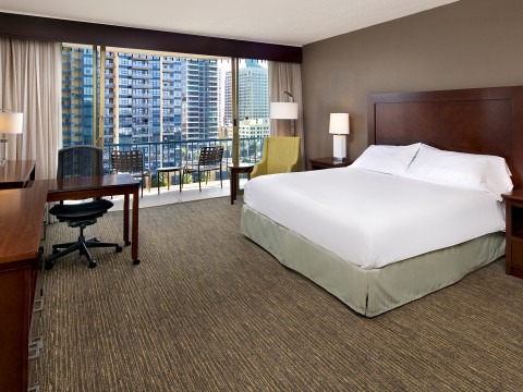 a hotel room with a large window overlooking a city