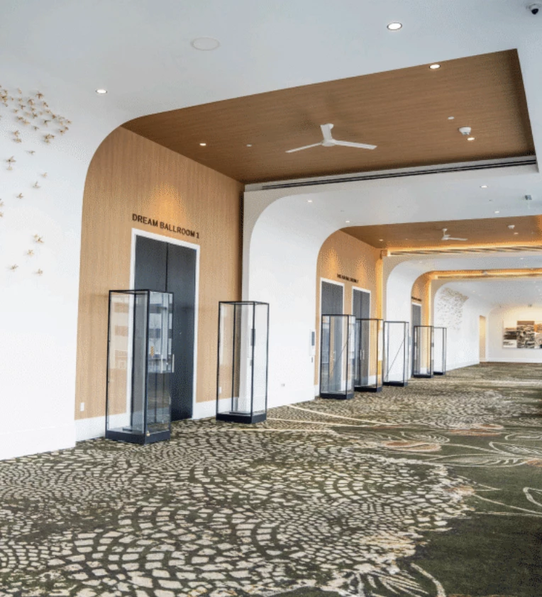 a hallway with glass cases and a ceiling fan