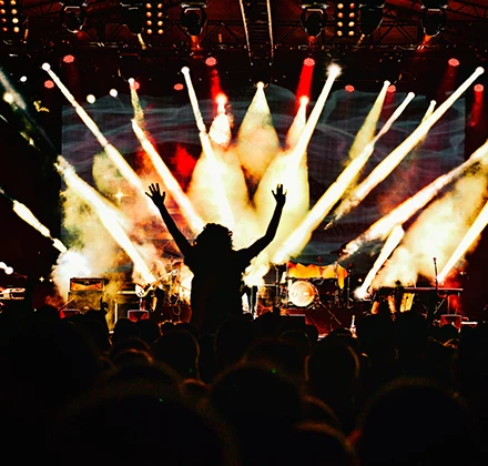 a crowd of people on a stage with a stage with lights and a crowd of people