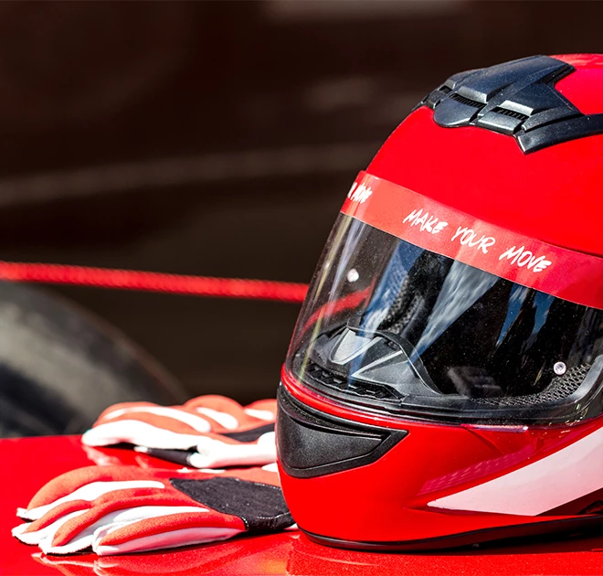 a helmet and gloves on a red surface